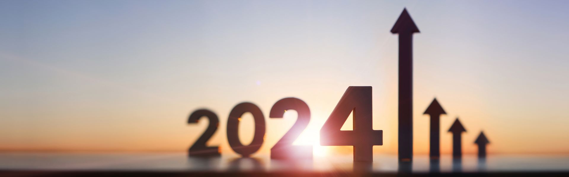 Le coucher de soleil illumine l'année 2024 avec des flèches qui montent vers le haut pour symboliser une éventuelle reprise du marché immobilier dans le Tarn en 2024