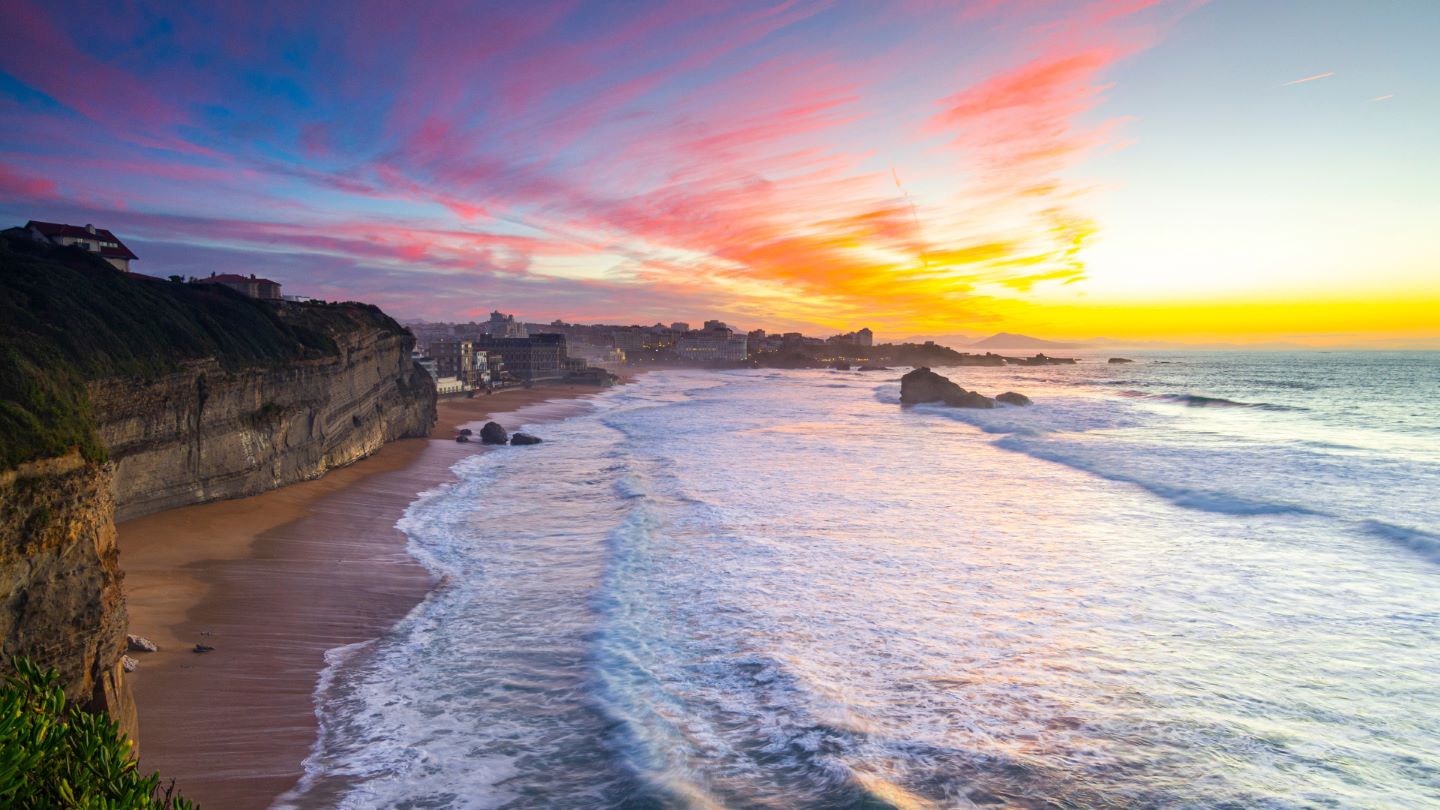 Un magnifique coucher de soleil sur une plage d'Anglet, où les vagues viennent se briser doucement sur le rivage