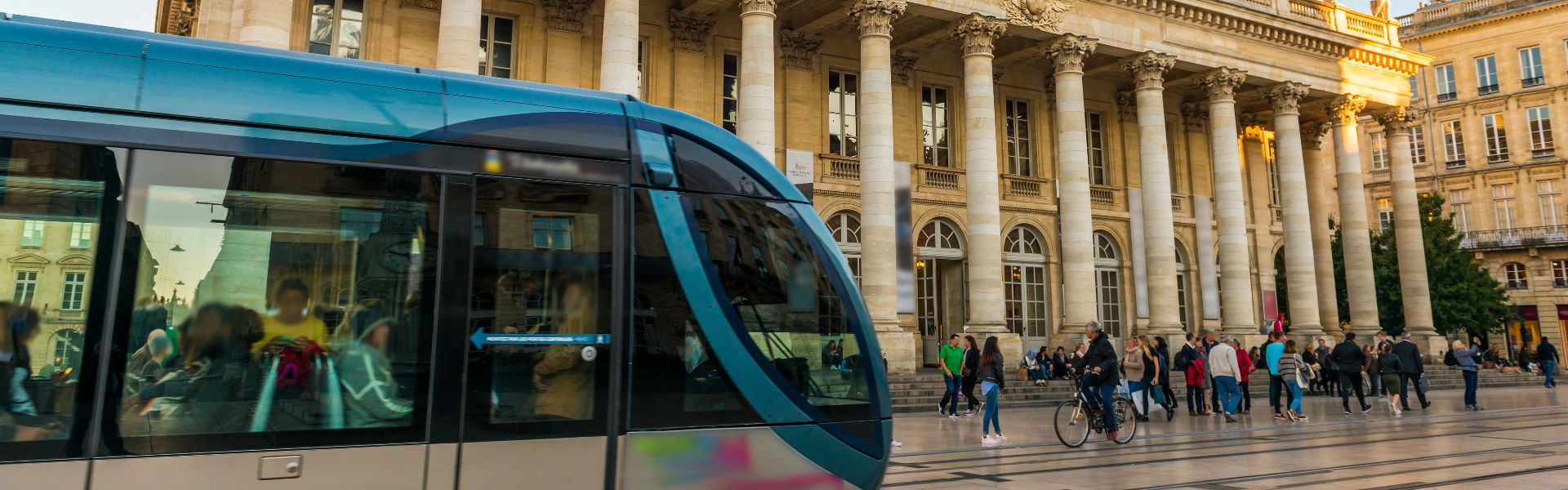 Vue sur un tram et un groupe de personnes se baladant au centre-ville de Bordeaux